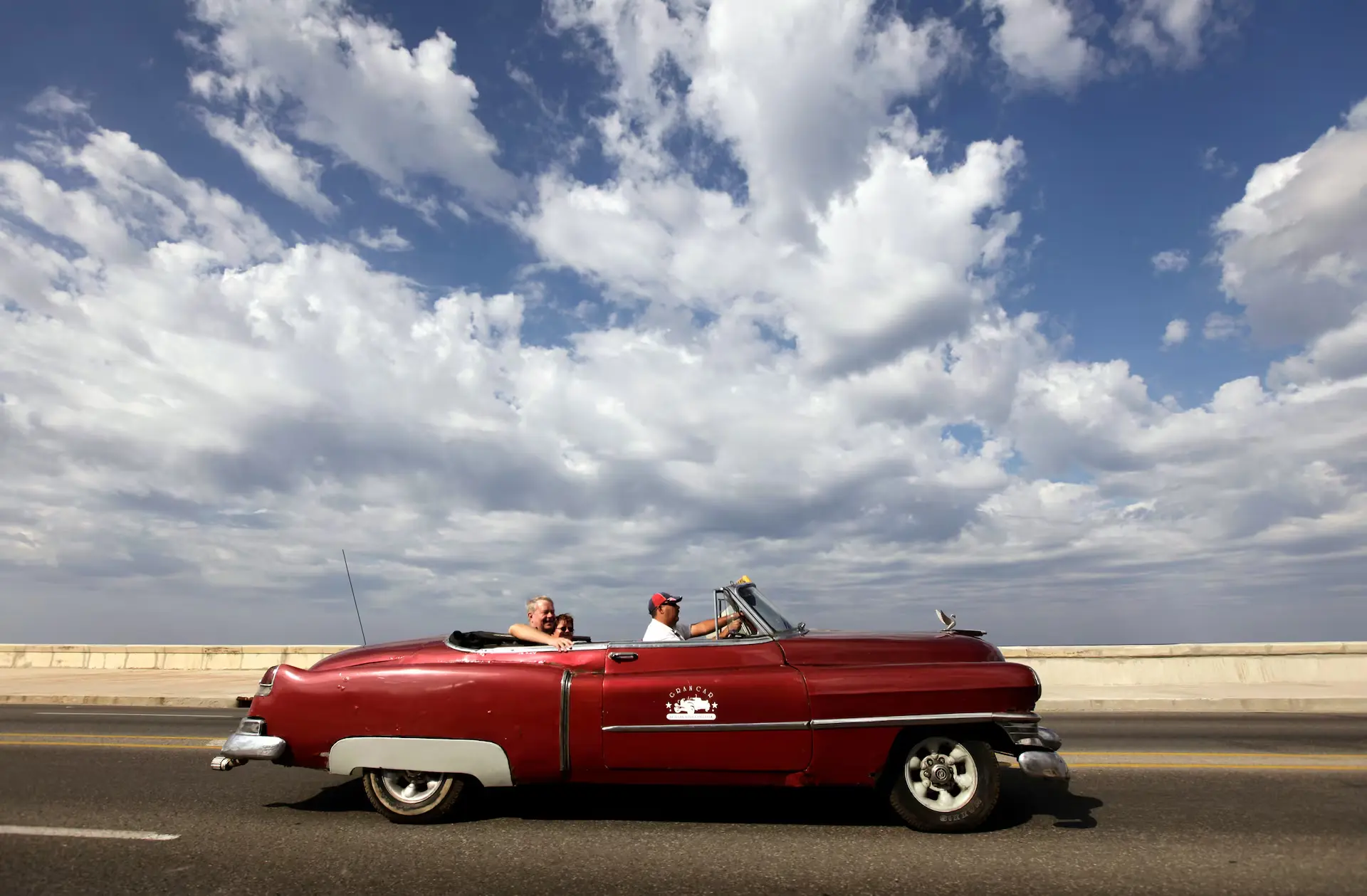 Classic 1950s American convertibles parked along Havanas Malecon