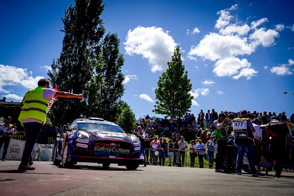 Fans safely watching from a marked spectator zone along a Safari Rally stage