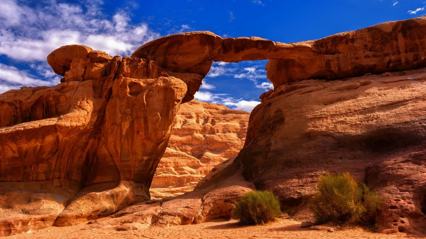 Red sand dunes and dramatic rock bridges of Wadi Rum desert